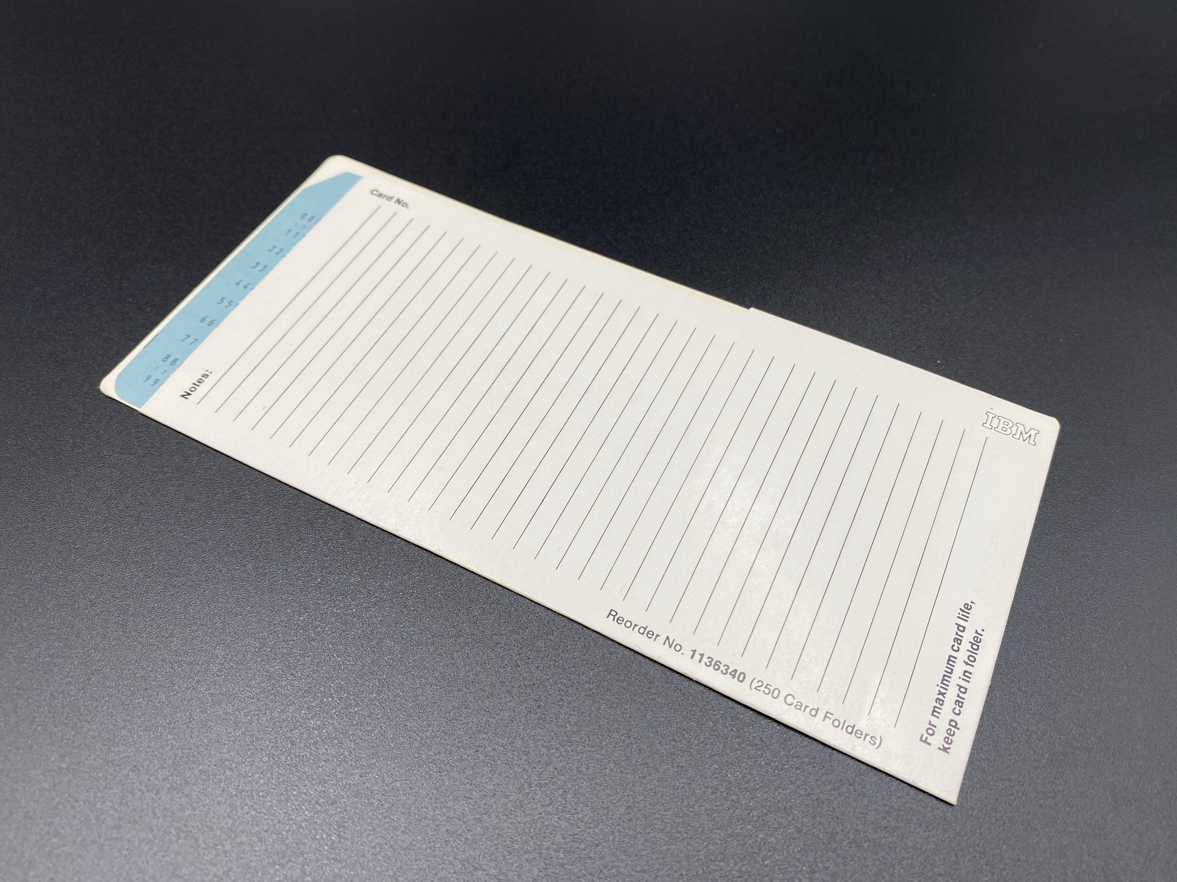 The card folder on a flat surface with a Blue IBM Ziffernkarte No 5 fully inserted.
