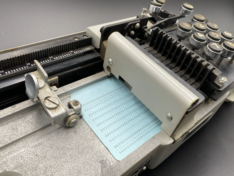 Detail of the card punch showing an 80 column card loaded into the carriage position to punch column 28.