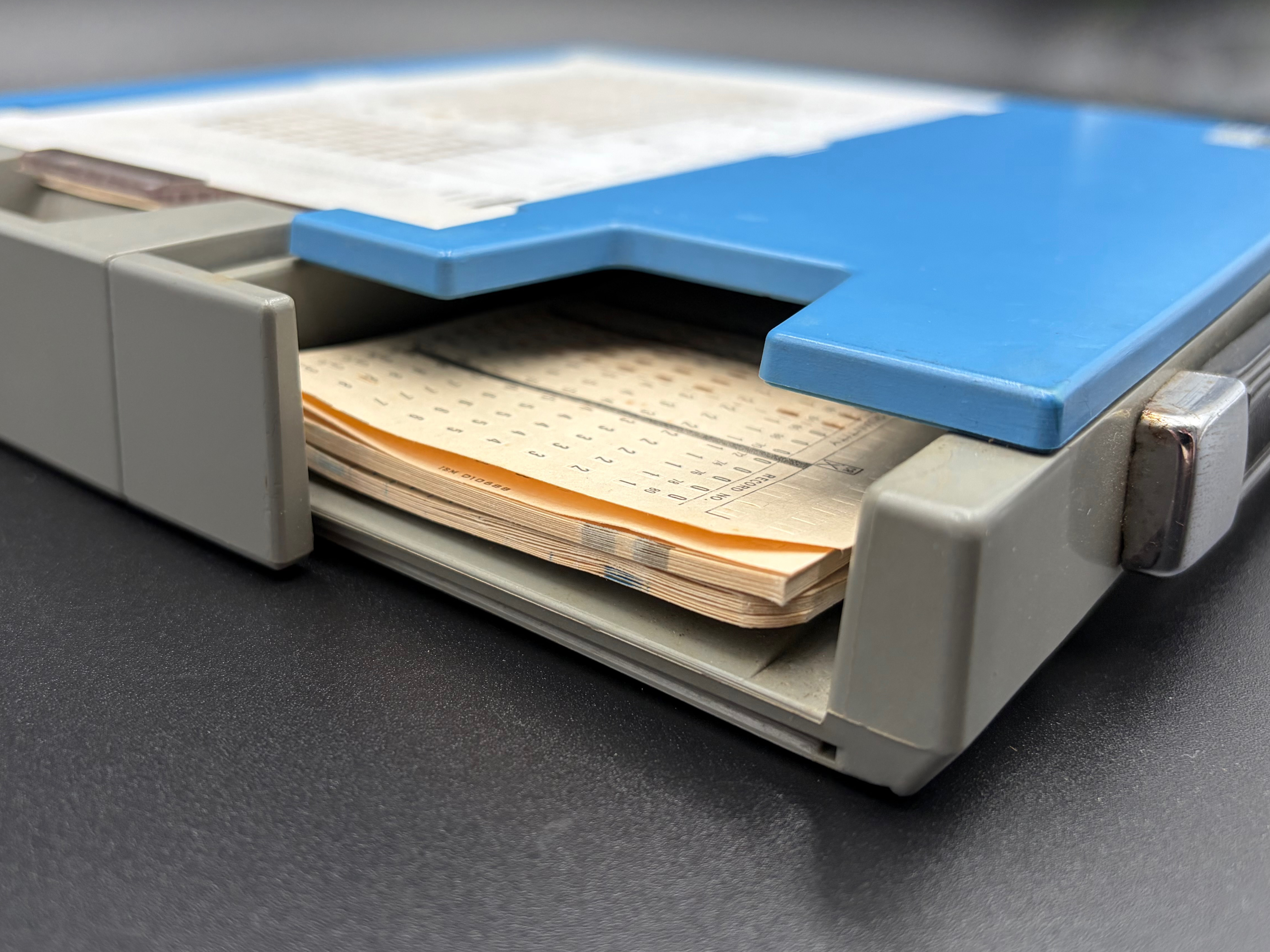 Detail of the storage compartment for additional punched or unpunched cards. A stack of different cards is shown inserted.