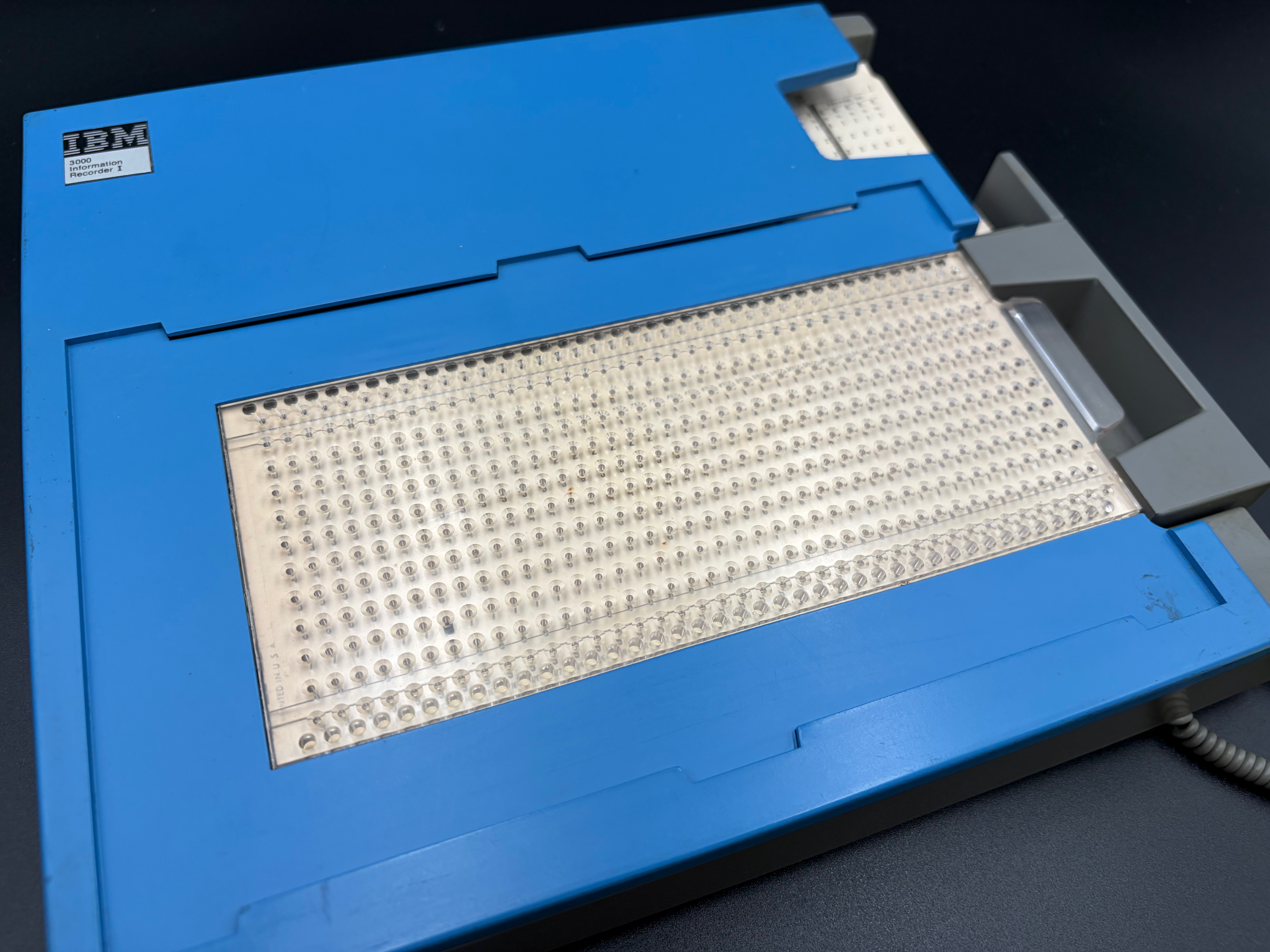 The punch area without the template overlay, showing the grid of holes in transparent plastic used for punching.