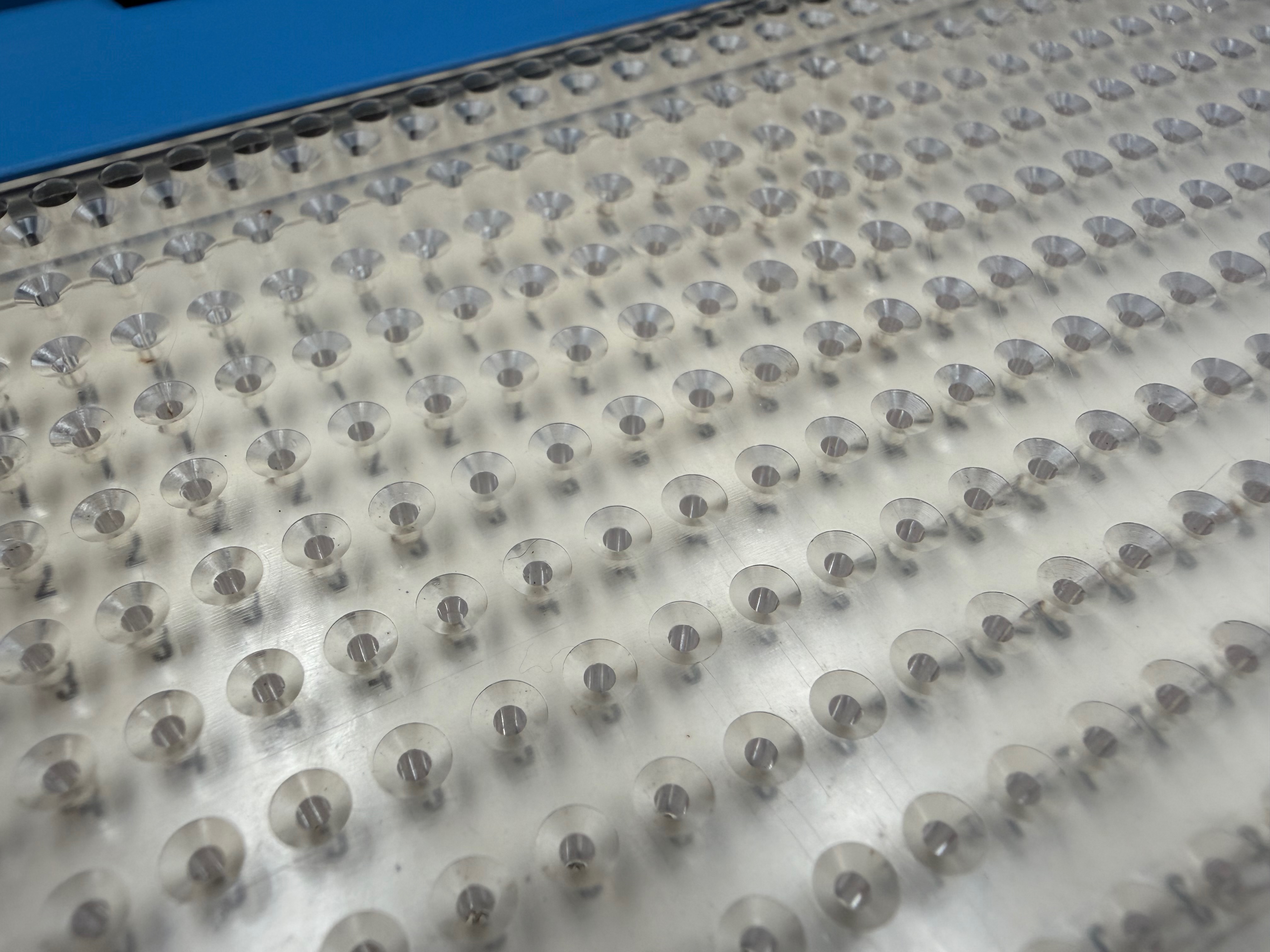 Macro detail of the transparent plastic punch guide showing an unpunched perforated card inserted underneath.