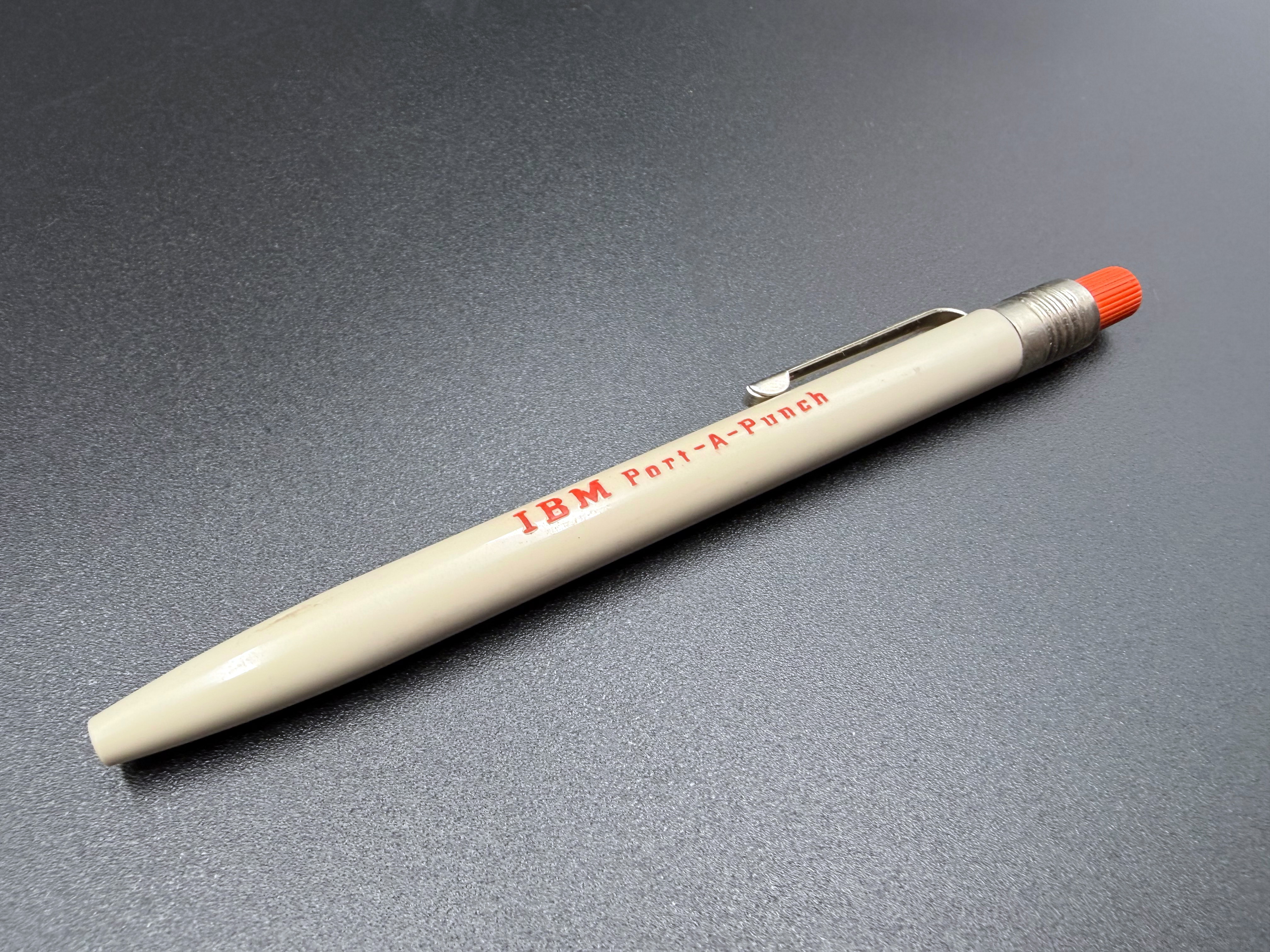 A single IBM Port-a-Punch Stylus removed from the box. The stylus punch tip is retracted.