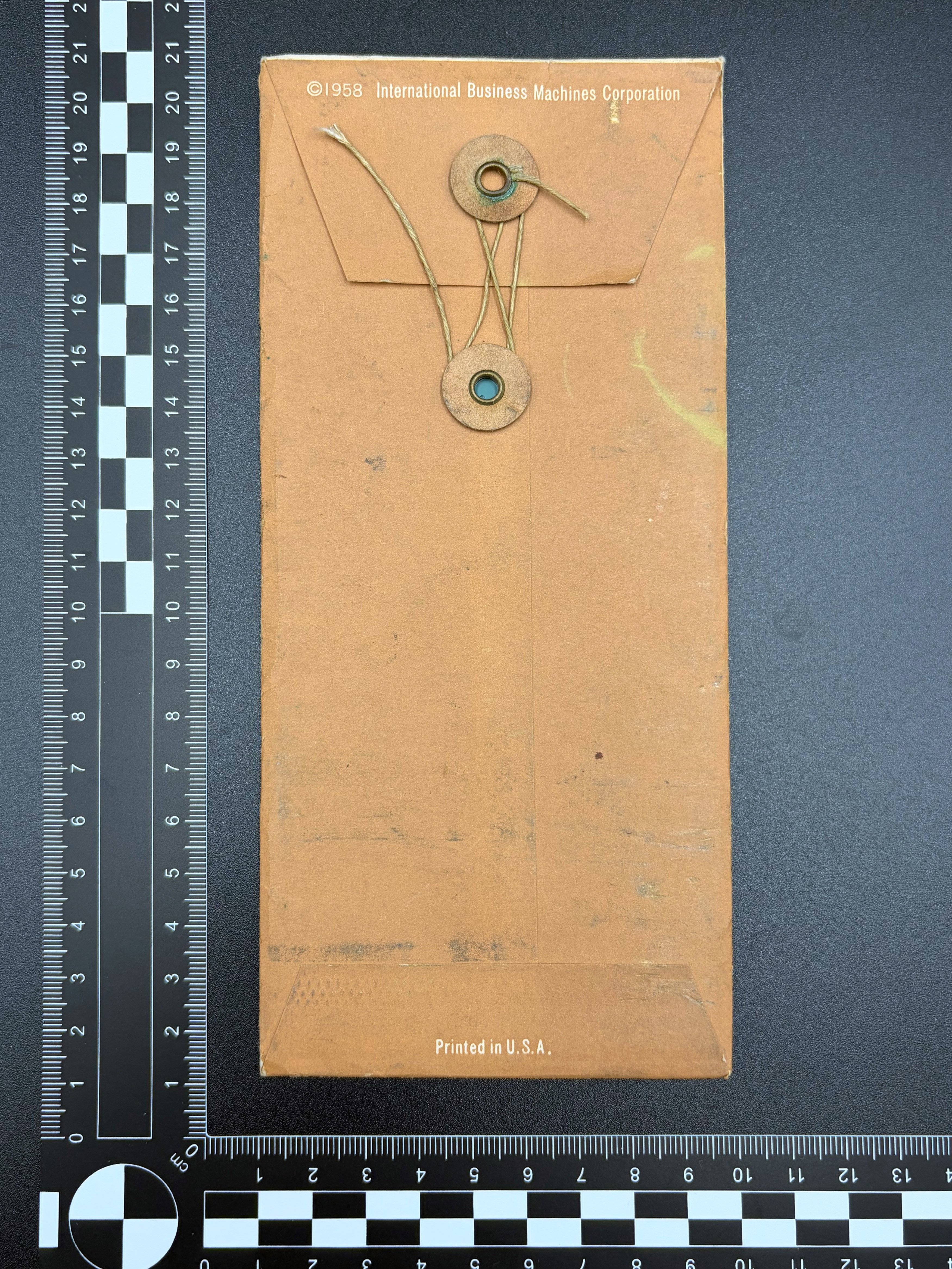 The rear of the punching template envelope showing the printed text and string tie closure.